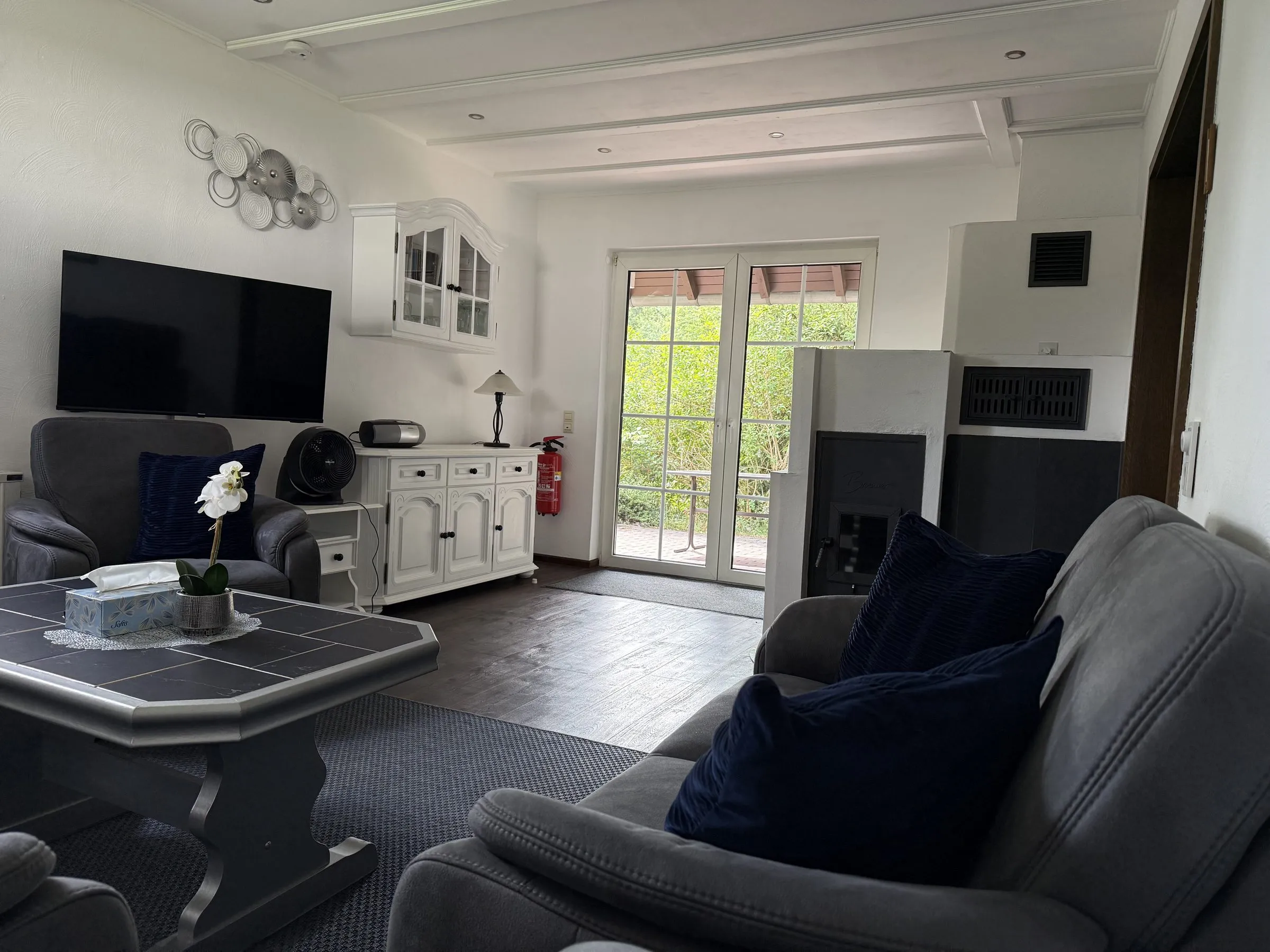 Wohnbereich mit Sideboard und Zugang zur Terrasse
